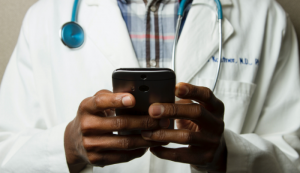 Doctor with stethoscope holding a phone